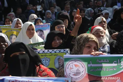 Palestinian women hold a poster of Palestinian prisoners during a protest calling for the release them from Israeli jails and in support of prisoners on hunger strike in front of Red Cross, in Gaza city on 26 November 20...