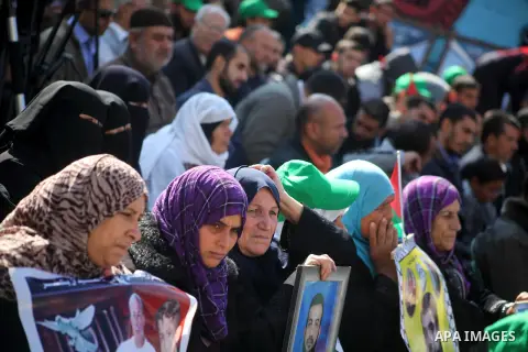 Palestinian women hold a poster of Palestinian prisoners during a protest calling for the release them from Israeli jails and in support of prisoners on hunger strike in front of Red Cross, in Gaza city on 26 November 20...