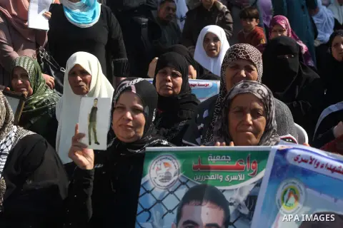 Palestinian women hold a poster of Palestinian prisoners during a protest calling for the release them from Israeli jails and in support of prisoners on hunger strike in front of Red Cross, in Gaza city on 26 November 20...