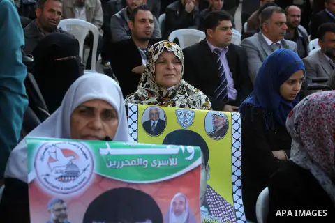 Palestinian women hold a poster of Palestinian prisoners during a protest calling for the release them from Israeli jails and in support of prisoners on hunger strike in front of Red Cross, in Gaza city on 26 November 20...