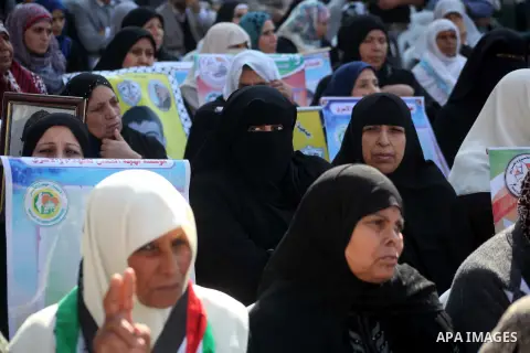 Palestinian women hold a poster of Palestinian prisoners during a protest calling for the release them from Israeli jails and in support of prisoners on hunger strike in front of Red Cross, in Gaza city on 26 November 20...