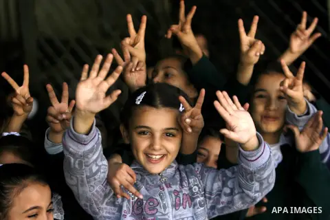 Palestinian school girls flash the victory sign in a destroyed school on November 26, 2012 in Rafah southern Gaza strip. The school was damaged some days ago, before a truce between Hamas and Israel ended eight days of c...