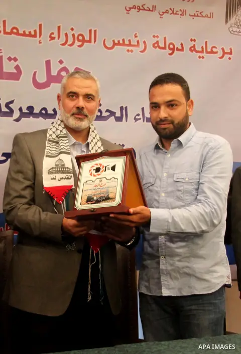 Palestinian Prime Minister in Gaza strip Ismail Haniyeh honors Ashraf Amra, in Gaza city on November 26, 2012. Amra works in APAimages photo agency, he was wounded after an Israeli air strike targeted a media bulding in...