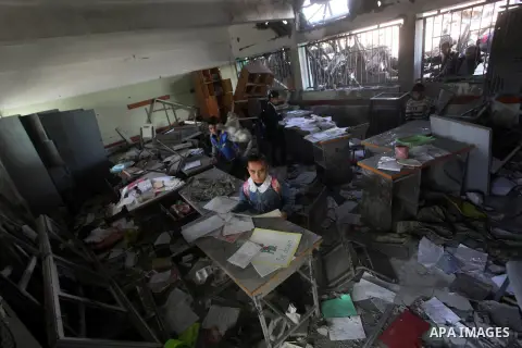 Palestinian school girls inspect the damage in a classroom in a destroyed school after days of Israeli air strikes destroyed the Hamas Interior Ministry in Gaza City. n November 26, 2012. The school was damaged some days...