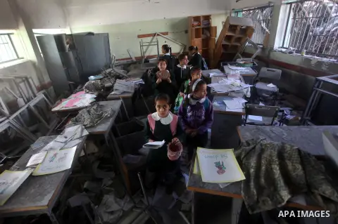 Palestinian school girls inspect the damage in a classroom in a destroyed school after days of Israeli air strikes destroyed the Hamas Interior Ministry in Gaza City. n November 26, 2012. The school was damaged some days...