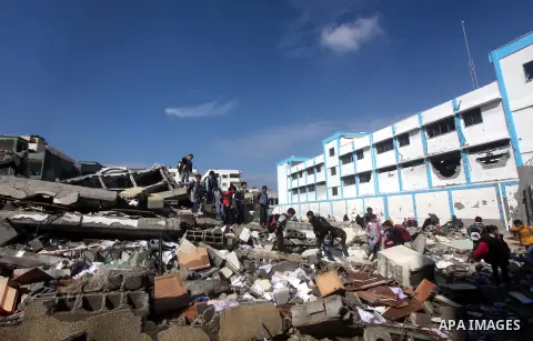 Palestinian school boys walk in the rubble left after days of Israeli air strikes destroyed the Hamas Interior Ministry in Gaza City. n November 26, 2012. The school was damaged some days ago, before a truce between Hama...