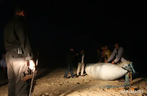 Palestinians stand next to what they said a part of an Israeli warplane on the beach of Rafah in southern Gaza strip, November 26, 2012. According to Hamas sources, Palestinian militant groups in the Gaza strip shot down...