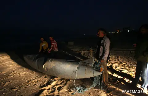 Palestinians stand next to what they said a part of an Israeli warplane on the beach of Rafah in southern Gaza strip, November 26, 2012. According to Hamas sources, Palestinian militant groups in the Gaza strip shot down...