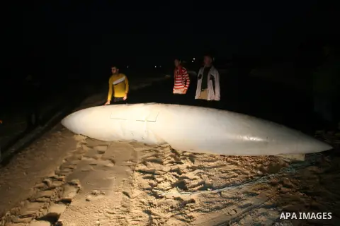 Palestinians stand next to what they said a part of an Israeli warplane on the beach of Rafah in southern Gaza strip, November 26, 2012. According to Hamas sources, Palestinian militant groups in the Gaza strip shot down...