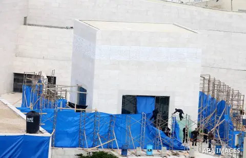 workers and an unidentified man wearing a forensic protective suit stand in front the mausoleum of the later Palestinian leader Yasser Arafat, on November 27, 2012, at the Muqataa in the West Bank city of Ramallah. The r...