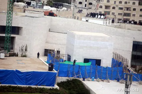 workers and an unidentified man wearing a forensic protective suit stand in front the mausoleum of the later Palestinian leader Yasser Arafat, on November 27, 2012, at the Muqataa in the West Bank city of Ramallah. The r...