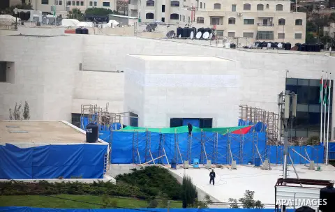 workers and an unidentified man wearing a forensic protective suit stand in front the mausoleum of the later Palestinian leader Yasser Arafat, on November 27, 2012, at the Muqataa in the West Bank city of Ramallah. The r...