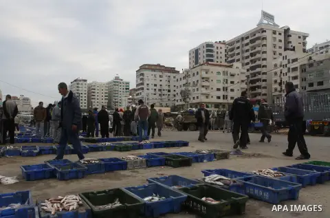 Palestinian men sell fish at a market in Gaza City November 27, 2012. Israel eased restrictions on Gaza fishermen on Saturday, further implementing truce brokered by Egypt after a week of fierce fighting, Palestinian off...