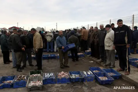 Palestinian men sell fish at a market in Gaza City November 27, 2012. Israel eased restrictions on Gaza fishermen on Saturday, further implementing truce brokered by Egypt after a week of fierce fighting, Palestinian off...
