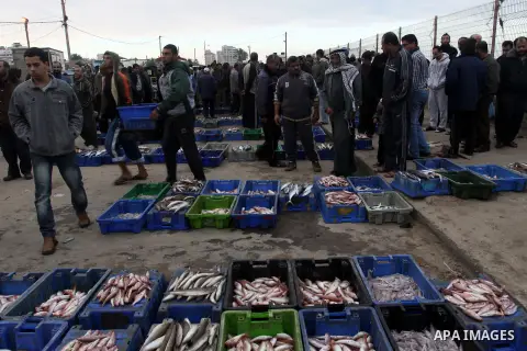 Palestinian men sell fish at a market in Gaza City November 27, 2012. Israel eased restrictions on Gaza fishermen on Saturday, further implementing truce brokered by Egypt after a week of fierce fighting, Palestinian off...