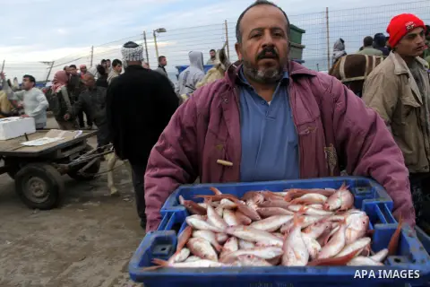 Palestinian men sell fish at a market in Gaza City November 27, 2012. Israel eased restrictions on Gaza fishermen on Saturday, further implementing truce brokered by Egypt after a week of fierce fighting, Palestinian off...