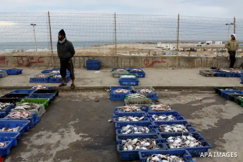 Palestinian men sell fish at a market in Gaza City November 27, 2012. Israel eased restrictions on Gaza fishermen on Saturday, further implementing truce brokered by Egypt after a week of fierce fighting, Palestinian off...