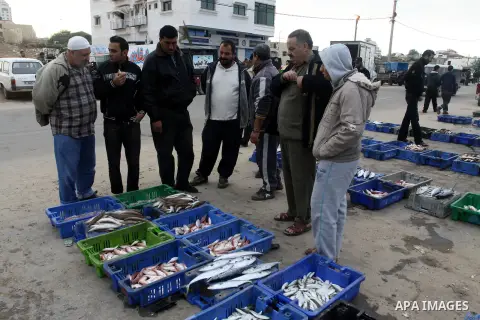Palestinian men sell fish at a market in Gaza City November 27, 2012. Israel eased restrictions on Gaza fishermen on Saturday, further implementing truce brokered by Egypt after a week of fierce fighting, Palestinian off...