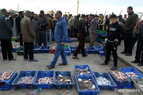 Palestinian men sell fish at a market in Gaza City November 27, 2012. Israel eased restrictions on Gaza fishermen on Saturday, further implementing truce brokered by Egypt after a week of fierce fighting, Palestinian off...