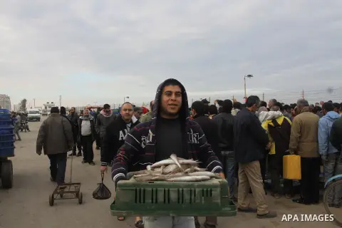 Palestinian men sell fish at a market in Gaza City November 27, 2012. Israel eased restrictions on Gaza fishermen on Saturday, further implementing truce brokered by Egypt after a week of fierce fighting, Palestinian off...