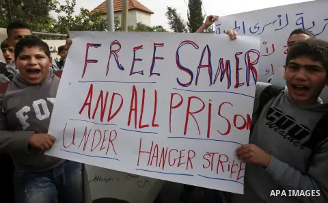 Relatives of Palestinians jailed in Israel demonstrate with placards of a detained prisoner, Tareq Issawi, who is on a hunger strike, as they protest for his release in Jerusalem, 27 November 2012. Photo by Mahfouz Abu T...