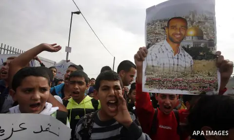 Relatives of Palestinians jailed in Israel demonstrate with placards of a detained prisoner, Tareq Issawi, who is on a hunger strike, as they protest for his release in Jerusalem, 27 November 2012. Photo by Mahfouz Abu T...