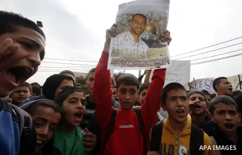 Relatives of Palestinians jailed in Israel demonstrate with placards of a detained prisoner, Tareq Issawi, who is on a hunger strike, as they protest for his release in Jerusalem, 27 November 2012. Photo by Mahfouz Abu T...