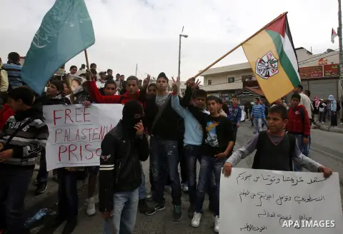 Relatives of Palestinians jailed in Israel demonstrate with placards of a detained prisoner, Tareq Issawi, who is on a hunger strike, as they protest for his release in Jerusalem, 27 November 2012. Photo by Mahfouz Abu T...