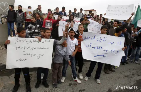 Relatives of Palestinians jailed in Israel demonstrate with placards of a detained prisoner, Tareq Issawi, who is on a hunger strike, as they protest for his release in Jerusalem, 27 November 2012. Photo by Mahfouz Abu T...