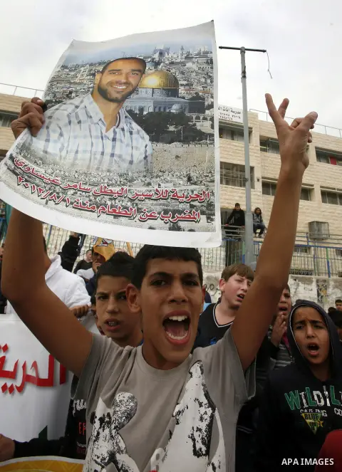 Relatives of Palestinians jailed in Israel demonstrate with placards of a detained prisoner, Tareq Issawi, who is on a hunger strike, as they protest for his release in Jerusalem, 27 November 2012. Photo by Mahfouz Abu T...