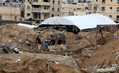 Palestinians work at the entrance of a smuggling tunnels dug beneath the Egyptian-Gaza border in Rafah, in the southern Gaza Strip November 27, 2012. Knee-deep in craters carved out by Israeli air strikes, Palestinians w...