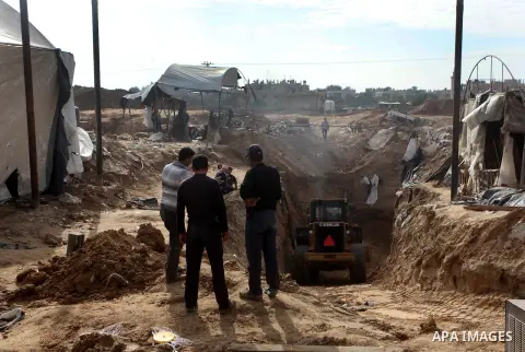 Palestinians work at the entrance of a smuggling tunnels dug beneath the Egyptian-Gaza border in Rafah, in the southern Gaza Strip November 27, 2012. Knee-deep in craters carved out by Israeli air strikes, Palestinians w...