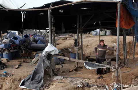 Palestinians work at the entrance of a smuggling tunnels dug beneath the Egyptian-Gaza border in Rafah, in the southern Gaza Strip November 27, 2012. Knee-deep in craters carved out by Israeli air strikes, Palestinians w...