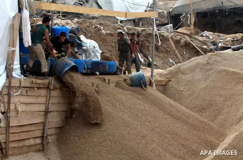Palestinians work at the entrance of a smuggling tunnels dug beneath the Egyptian-Gaza border in Rafah, in the southern Gaza Strip November 27, 2012. Knee-deep in craters carved out by Israeli air strikes, Palestinians w...