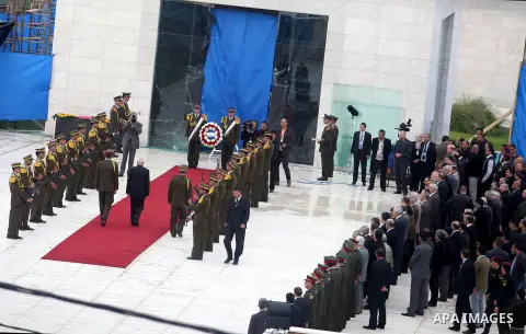 Palestinian presidency head Tayeb Abdelrahim (C-R) walks between lines of Palestinian honour guards standing to attention as he leaves the mausoleum of the late Palestinian leader Yasser Arafat, after a funeral ceremony...