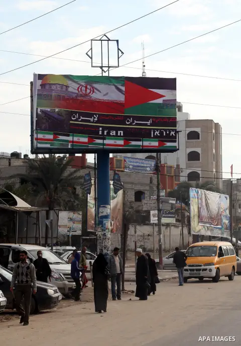 Palestinians walk next to a placard reads in Arabic "Thanks for Iran" in Gaza city on November 27, 2012. The commander of Iran's elite Revolutionary Guards has publicly admitted that his forces supplied the Islamic milit...