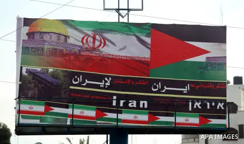Palestinians walk next to a placard reads in Arabic "Thanks for Iran" in Gaza city on November 27, 2012. The commander of Iran's elite Revolutionary Guards has publicly admitted that his forces supplied the Islamic milit...