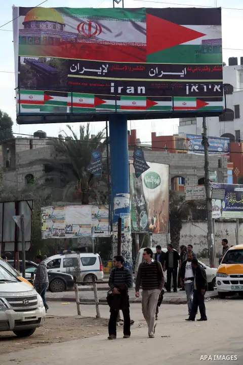 Palestinians walk next to a placard reads in Arabic "Thanks for Iran" in Gaza city on November 27, 2012. The commander of Iran's elite Revolutionary Guards has publicly admitted that his forces supplied the Islamic milit...