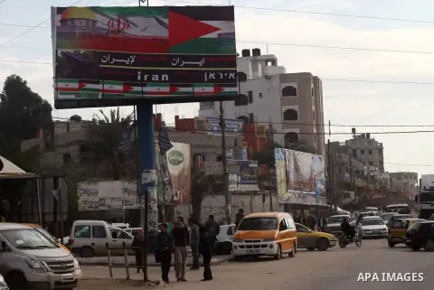 Palestinians walk next to a placard reads in Arabic "Thanks for Iran" in Gaza city on November 27, 2012. The commander of Iran's elite Revolutionary Guards has publicly admitted that his forces supplied the Islamic milit...