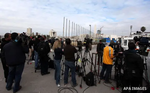 The local and international press gather meters away from the mausoleum of the late Palestinian leader Yasser Arafat, protected by blue tarpaulin on November 27, 2012, at the Muqataa in the West Bank city of Ramallah. Th...