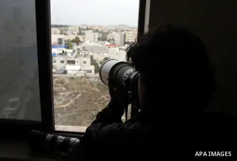 A Palestinian photographer takes photos for the mausoleum of the late Palestinian leader Yasser Arafat, protected by blue tarpaulin on November 27, 2012, at the Muqataa in the West Bank city of Ramallah. The remains of i...