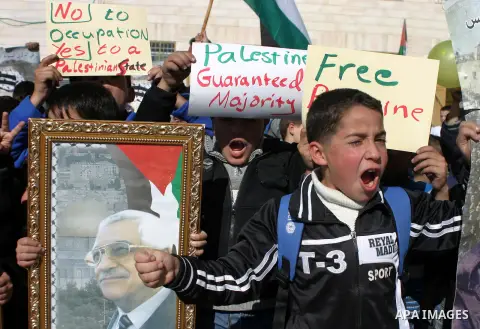 Palestinians student hold posters of Palestinian President Mahmoud Abbas during a rally supporting the Palestinian UN bid for observer state status, in the West Bank city of Hebron, Nov. 28, 2012. The Palestinians will r...