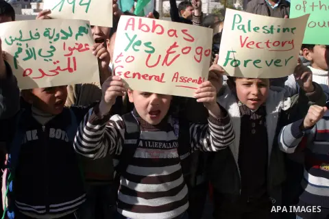 Palestinians student hold posters of Palestinian President Mahmoud Abbas during a rally supporting the Palestinian UN bid for observer state status, in the West Bank city of Hebron, Nov. 28, 2012. The Palestinians will r...