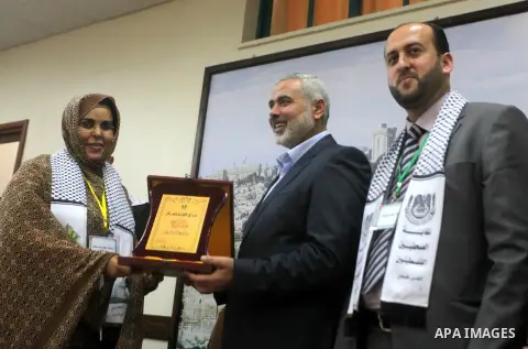 Palestinian Prime Minister in Gaza strip Ismail Haniyeh honors Makram Ahmed a member of delegation of the General Union of Arab journalists in Gaza city on November 28, 2012. Israeli aircraft killed 3 and wounded more th...