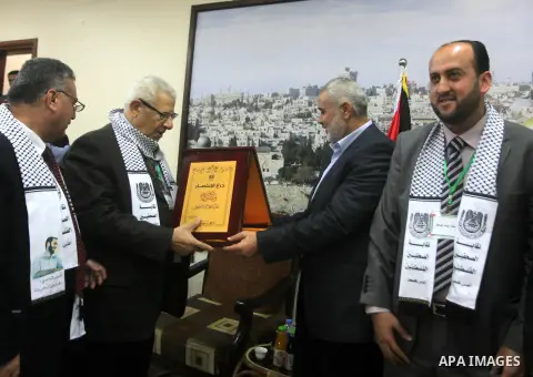 Palestinian Prime Minister in Gaza strip Ismail Haniyeh honors Makram Ahmed, the Secretary General of the Arab Journalists Union in Gaza city on November 28, 2012. Israeli aircraft killed 3 and wounded more than 17 journ...