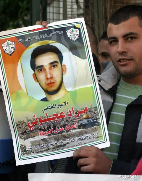 Palestinian protesters hold portraits of their relative prisoners held in an Israeli jails, during a solidarity sit-in outside the Red Cross offices in Jerusalem, on November 28, 2012. Demonstrators protested in solidari...