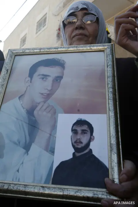 Palestinian protesters hold portraits of their relative prisoners held in an Israeli jails, during a solidarity sit-in outside the Red Cross offices in Jerusalem, on November 28, 2012. Demonstrators protested in solidari...