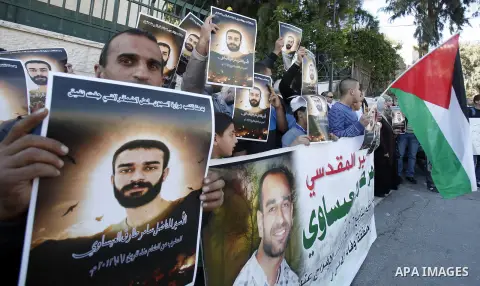 Palestinian protesters hold portraits of Samer Issawi, a Palestinian prisoner held in an Israeli jail and on hunger strike since August 1, during a solidarity sit-in outside the Red Cross offices in Jerusalem, on Novembe...