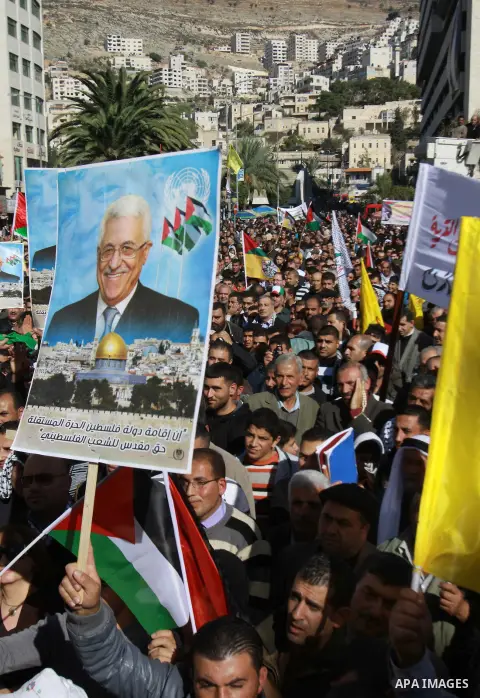 Palestinians hold up portraits of Palestinian President Mahmoud Abbas during a rally supporting the Palestinian UN bid for observer state status, in the West Bank city of Nablus, 29 November 2012. Abbas is to press the U...