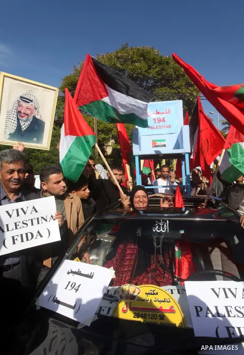 Palestinians take part in a rally in support of the efforts of President Mahmoud Abbas (pictured in poster) to secure a diplomatic upgrade at the United Nations, in Gaza City November 29, 2012. The U.N. General Assembly...